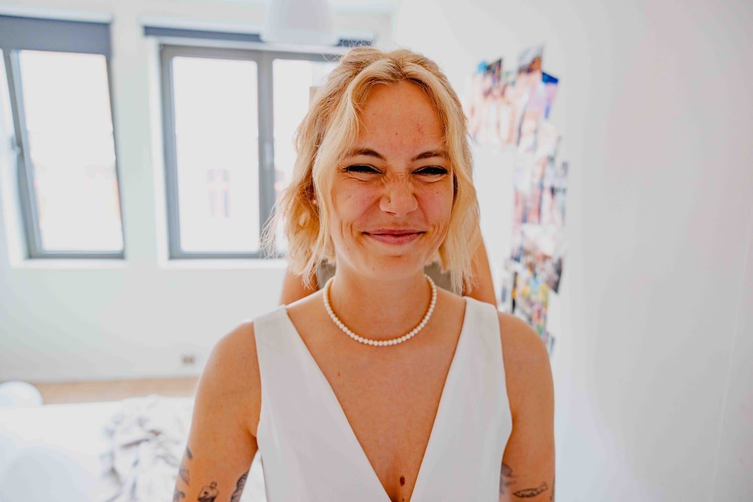 Bride laughing while getting ready in a bright room