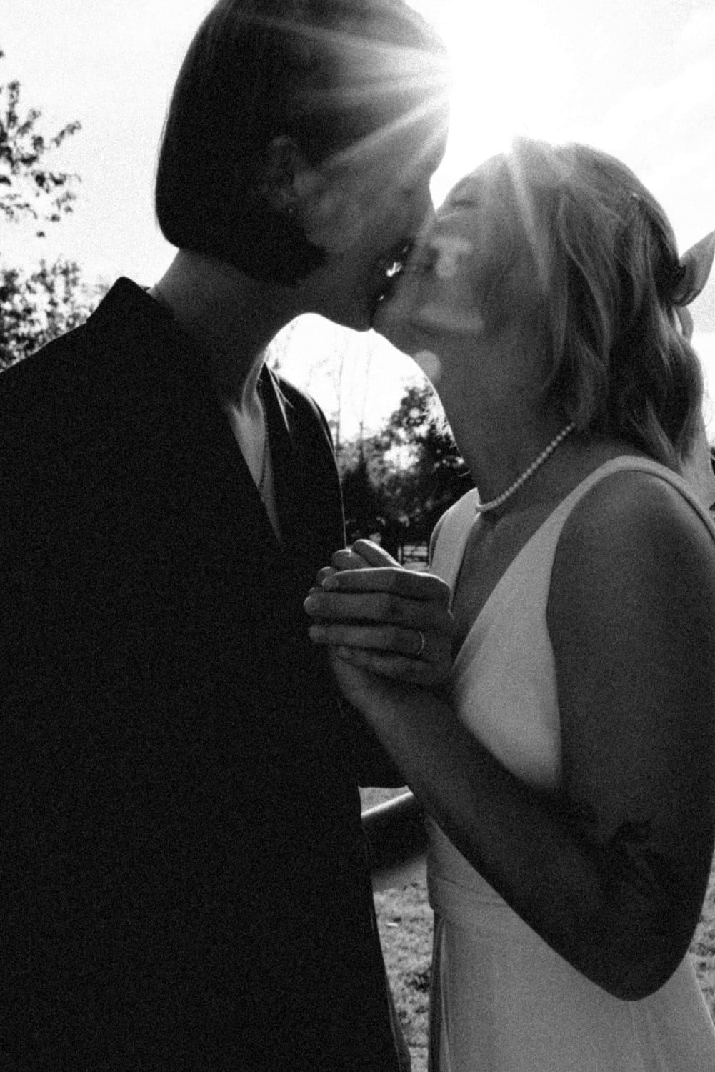 The couple kissing in the backlight of the sun, in black and white